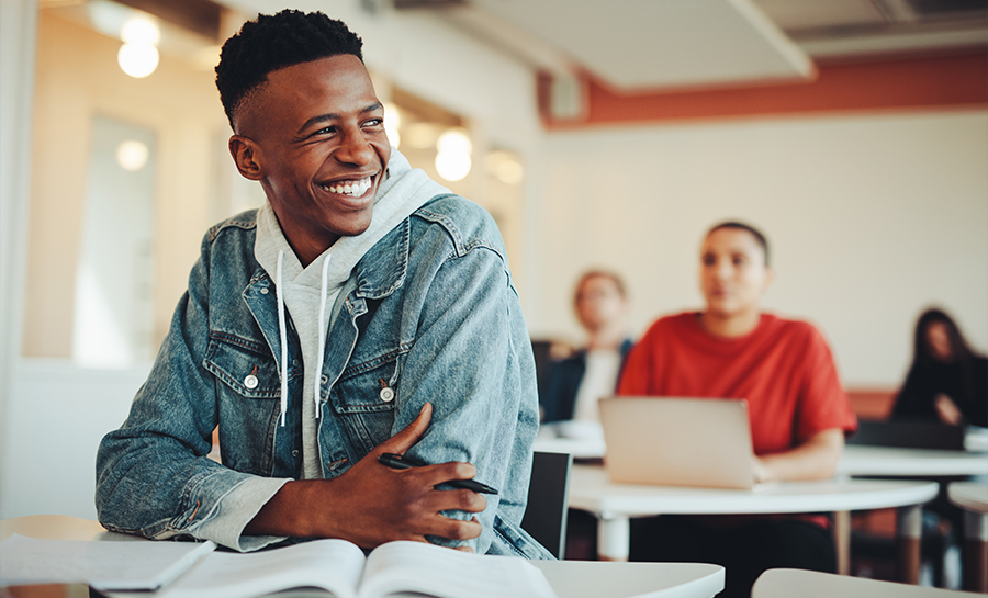 Student smiling at desk.