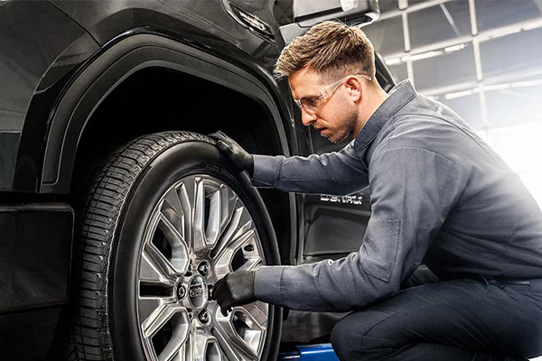 GM Service tech inspecting a tire