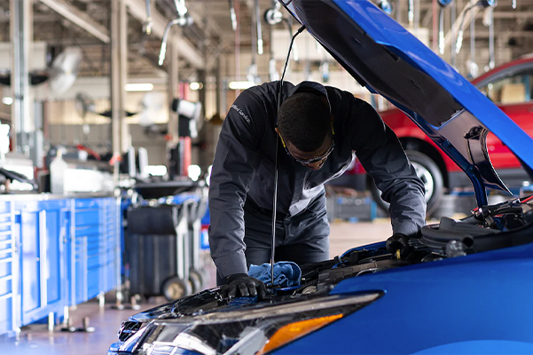 Service technician looking under the hood of a chevrolet
