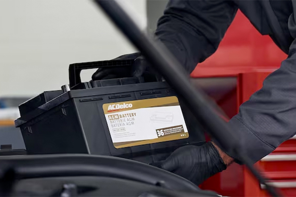 Chevrolet service technician replacing a battery in a vehicle